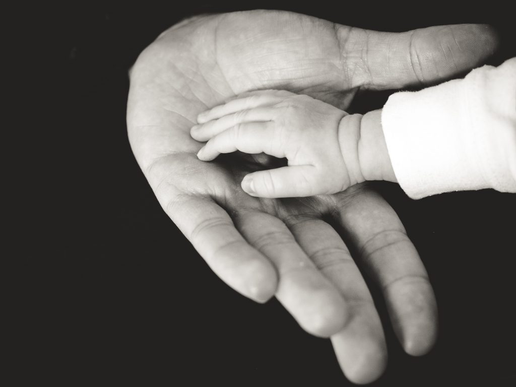 Baby handje in de hand van een volwassenen