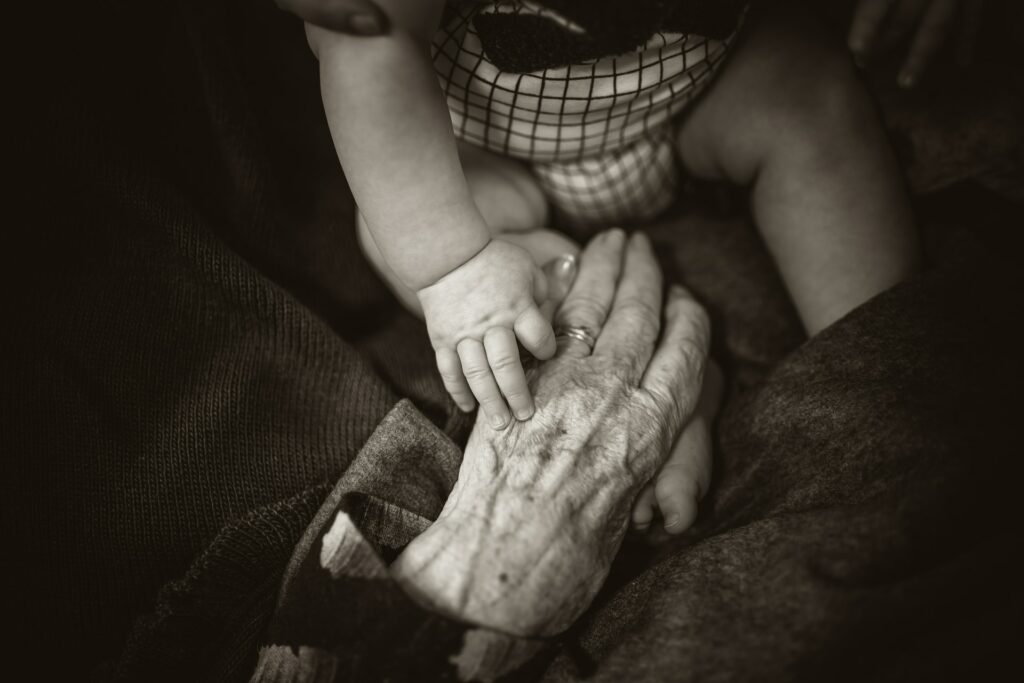 Baby houdt hand van grootouder vast